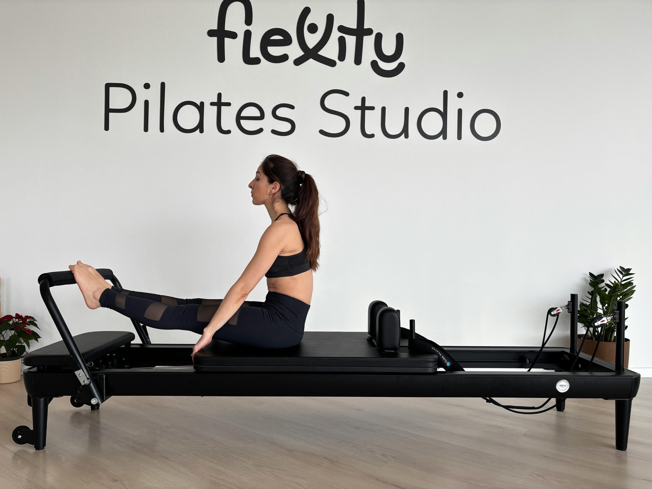 Erwachsene Frau macht Pilates-Ãbungen auf einem Reformer im Flexity Pilates Studio.