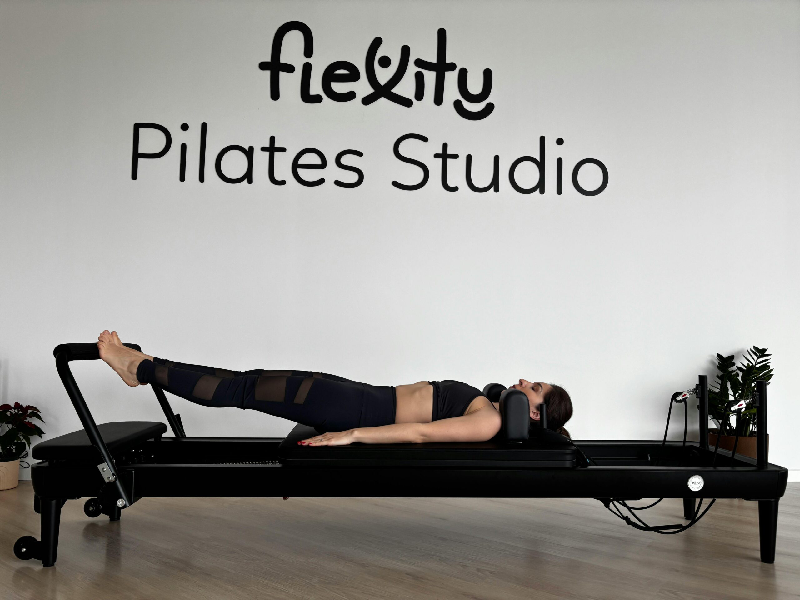 Eine Frau führt in einem modernen Studio Ãbungen auf einem Pilates-Reformer durch.