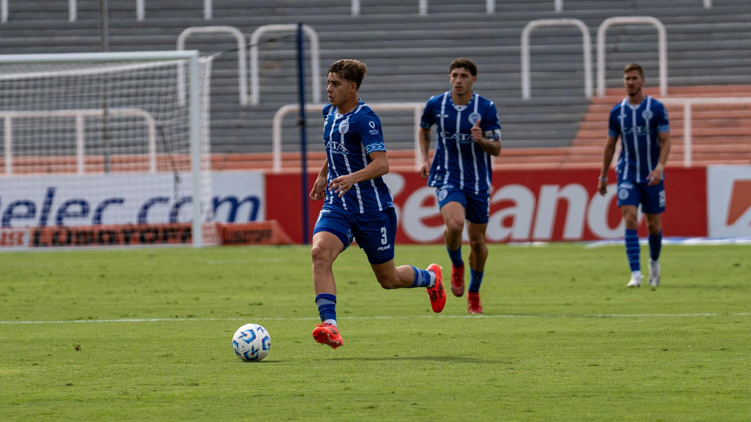 Spannender Moment während eines FuÃballspiels, wenn Spieler in blauen Uniformen auf dem Spielfeld die Kontrolle über den Ball übernehmen.