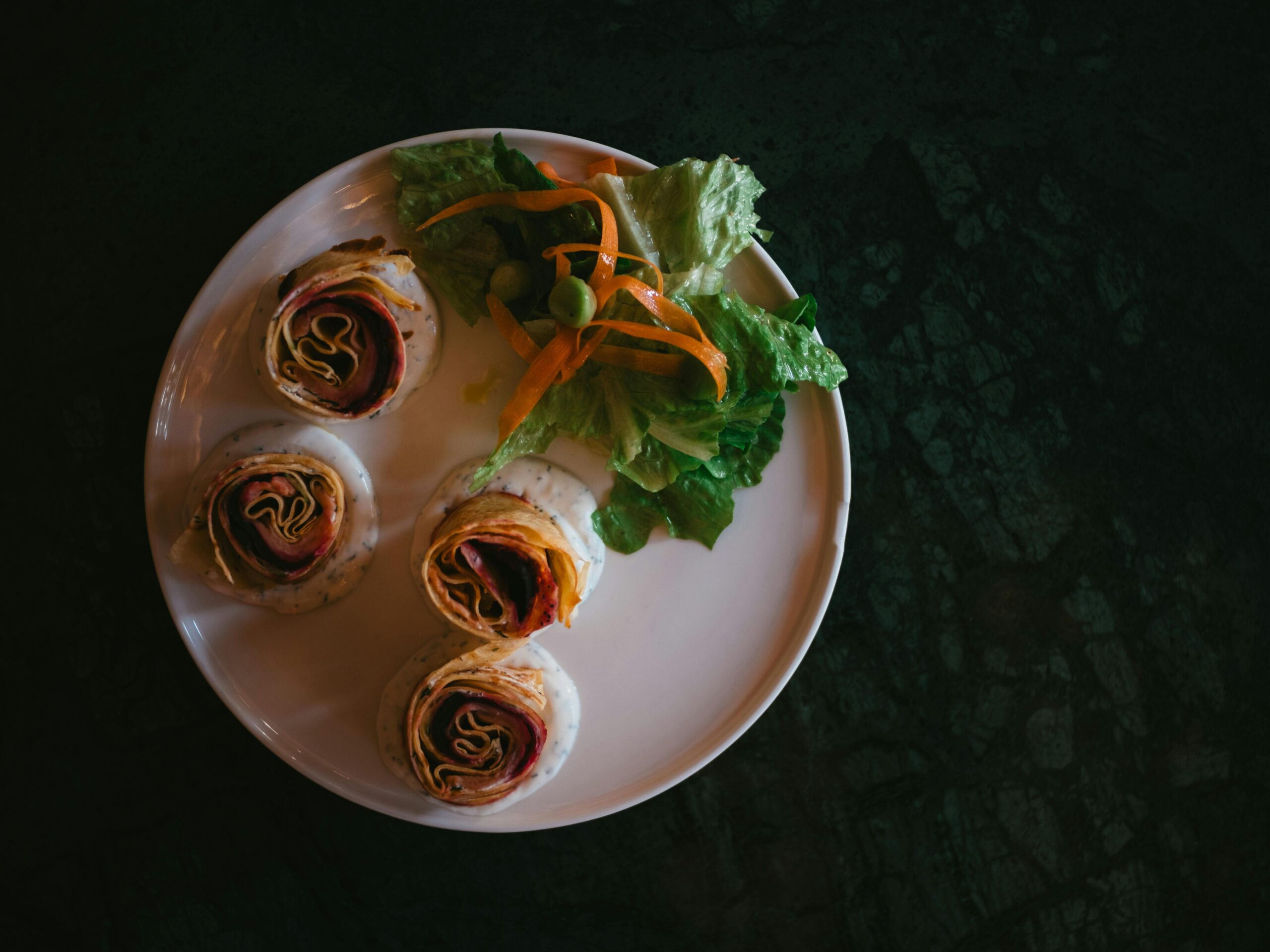 Appetitliche Wraps mit frischem Salat auf einem weiÃen Teller serviert, perfekt für eine gesunde Mahlzeit.