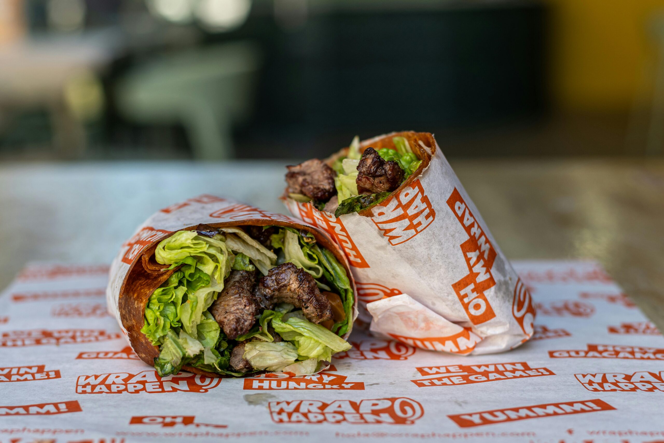 Leckerer Rindfleisch-Salat-Wrap auf Markenpapier in zwanglosem Ambiente.
