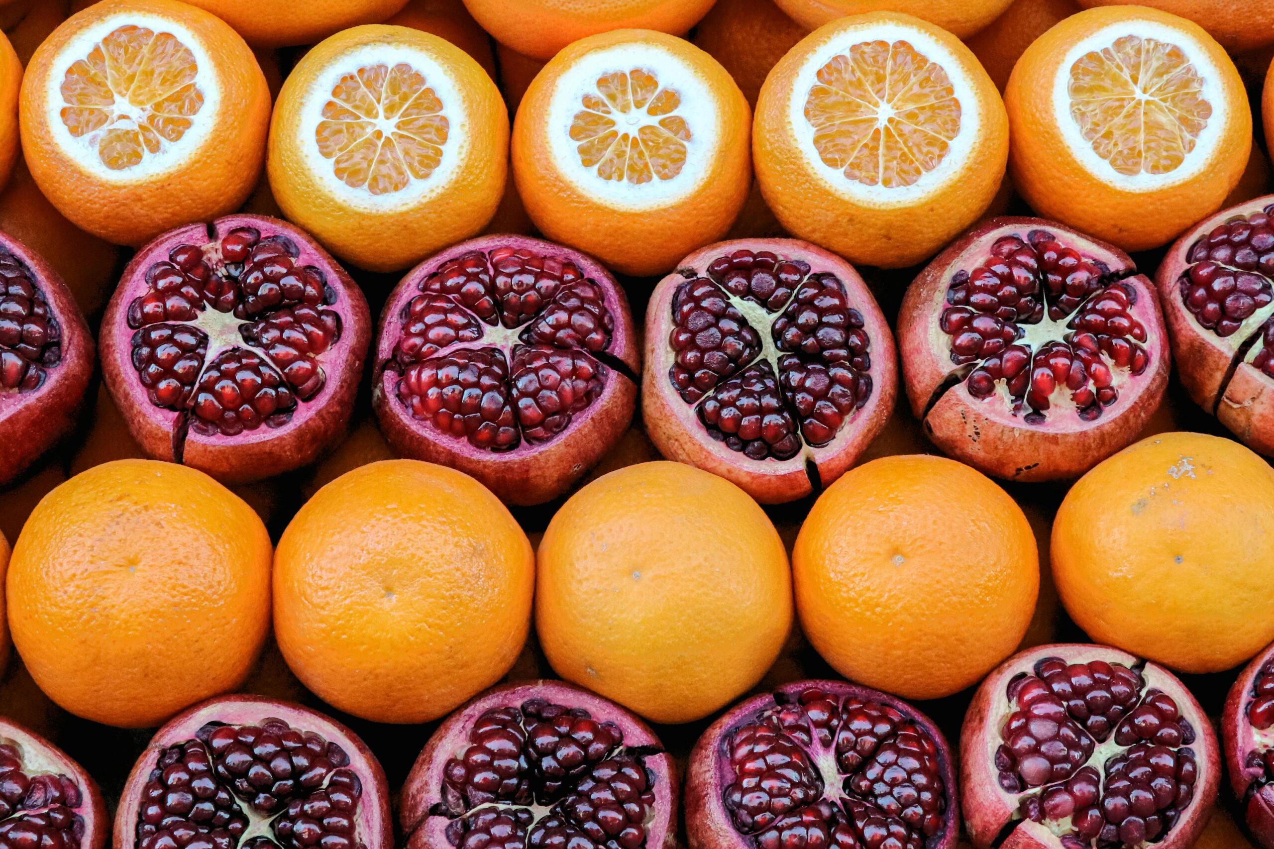 Lebendige Mischung aus geschnittenen Orangen und Granatäpfeln auf einem Obstmarkt in Istanbul, Türkei.