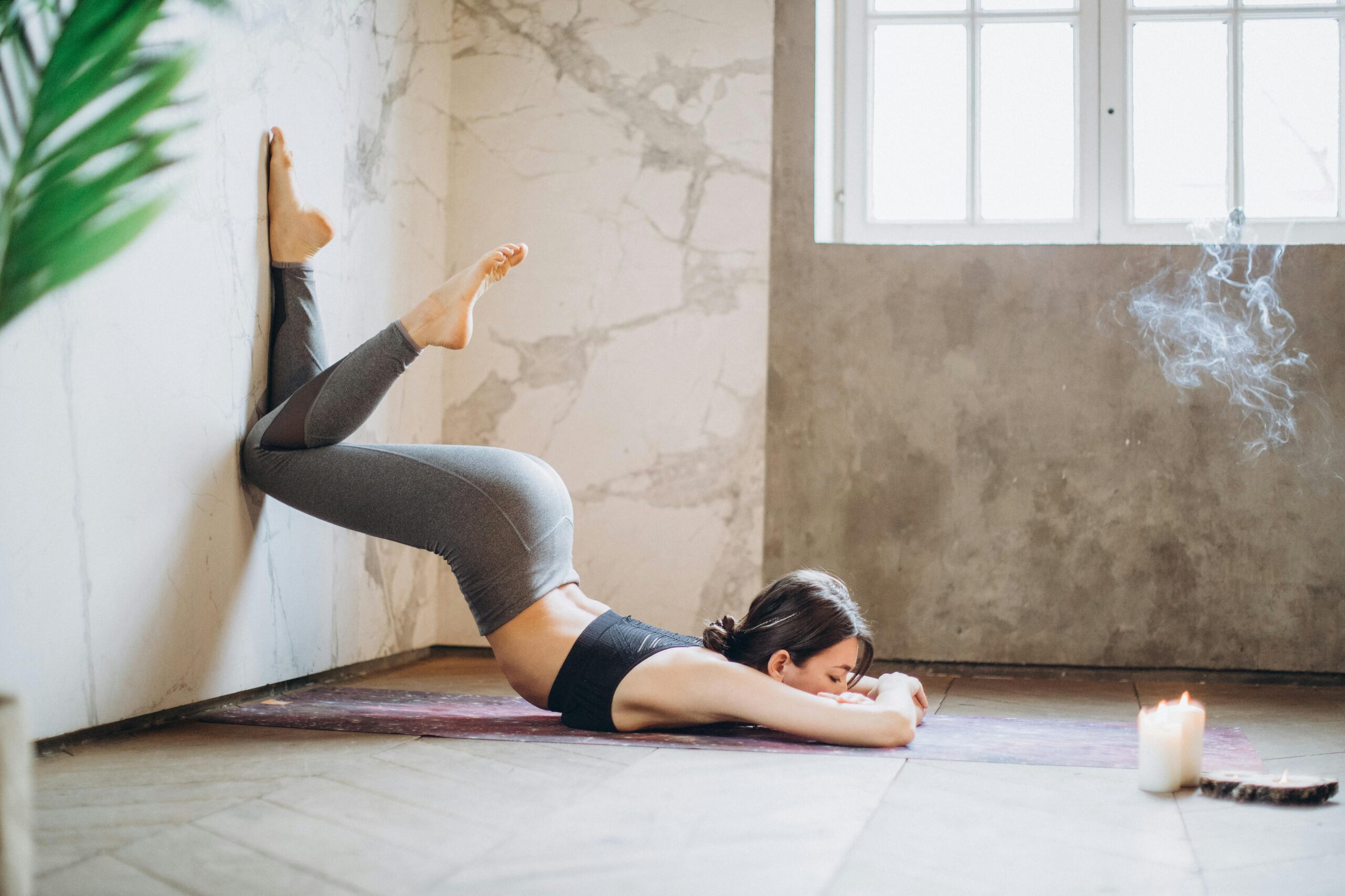 Frau In Grauen Leggings Und Schwarzem Trägershirt, Das Auf Yoga Matte Liegt, Die Yoga Tut