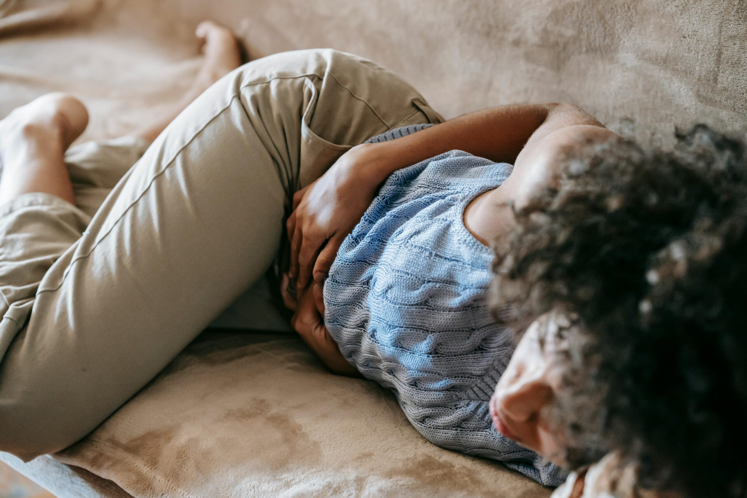 Kostenloses Stock Foto zu #indoor, auf der couch liegen, bauchkrämpfe