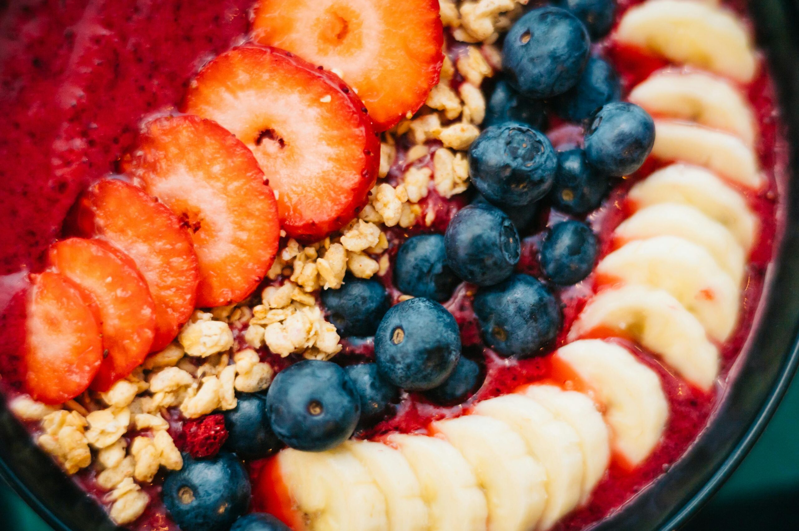 Lebendige Smoothie-Bowl mit frischen Früchten und Müsli, perfekt für einen gesunden Start.